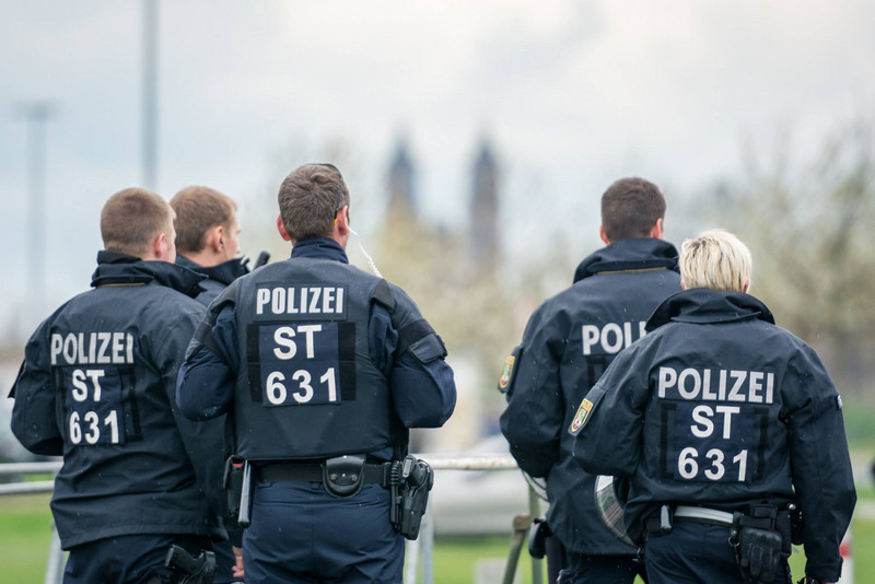 Fünf Polizeibeamte der Einsatzeinheit LSA von hinten zu sehen. Natur im Hintergrund.