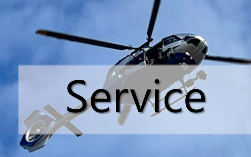 Polizeihubschrauber am blauen Himmel. Darüber liegend der Schriftzug Service.